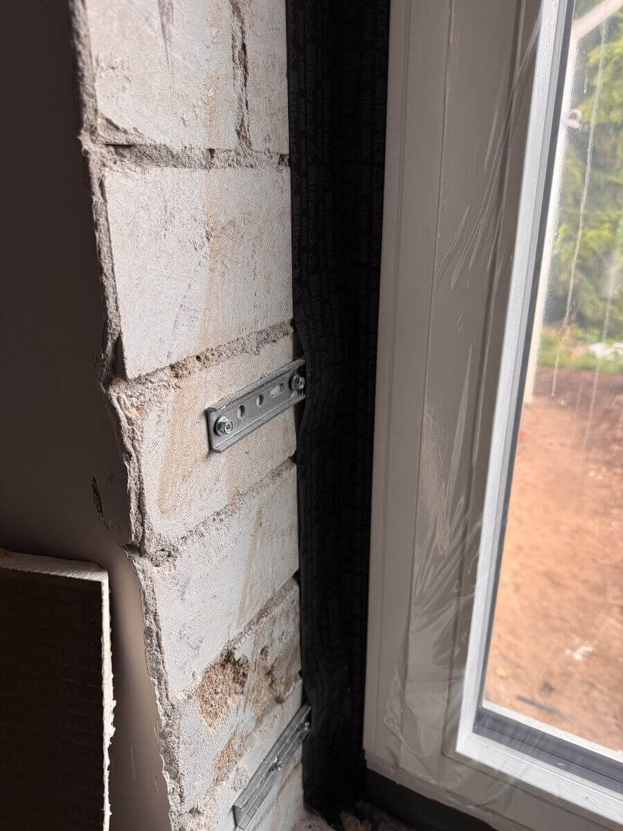 Fensterlaibung im Rohbau mit sichtbarem Mauerwerk und Dämmung